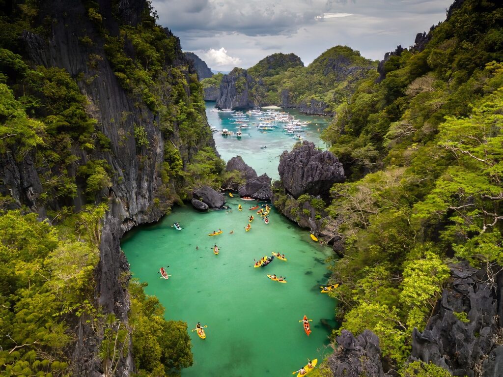 Boats dot coves in El Nido, Palawan, one of the top destinations listed in this Philippines travel guide.