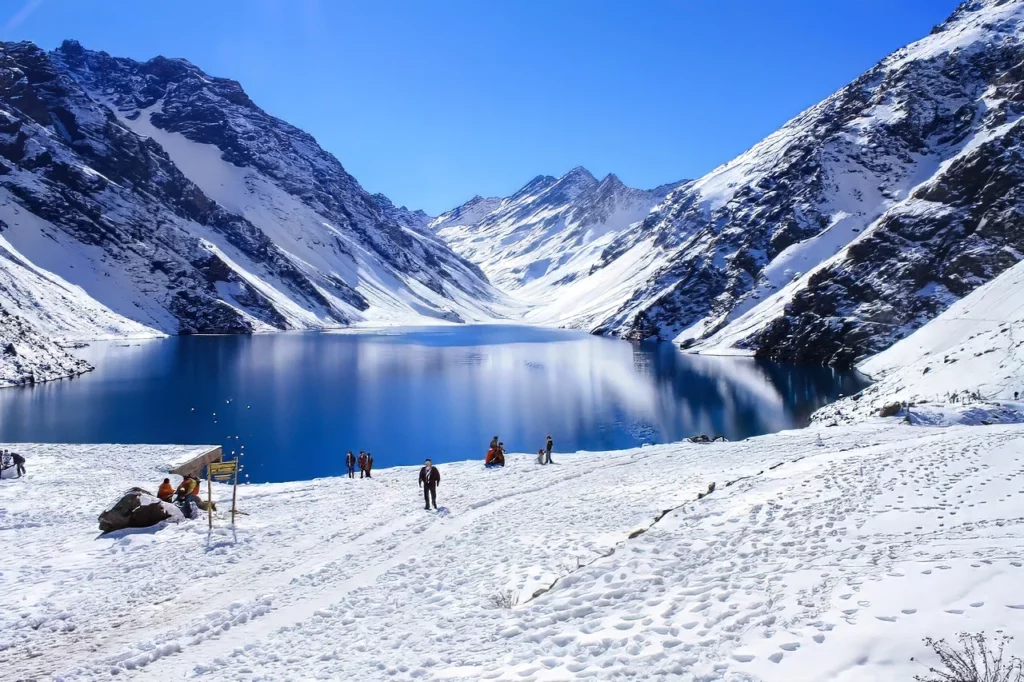 Tourists amid a glacial lake and towering Andes mountains, one of the locations featured in this Chile travel guide.