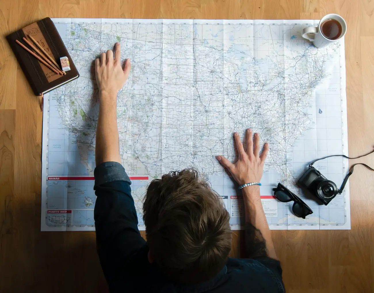 Traveler reviewing a map and organizing a travel planning checklist